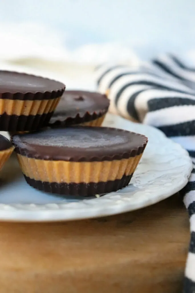 A front side view of a stack of low carb peanut butter cups on a white plate