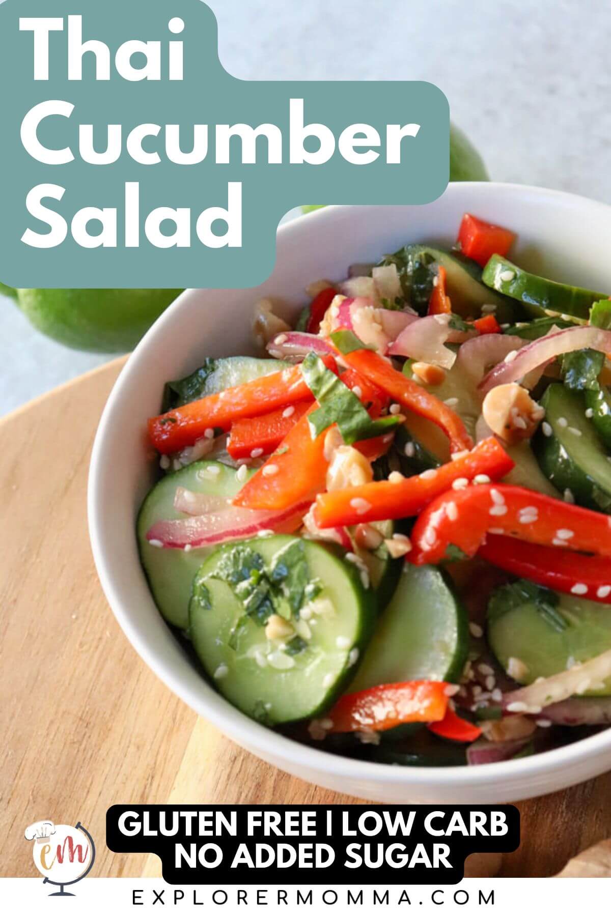 A white bowl of Thai cucumber salad with cucumbers, red peppers, and red onion, dotted with sesame seeds and cilantro. Sitting on a wooden circle board.