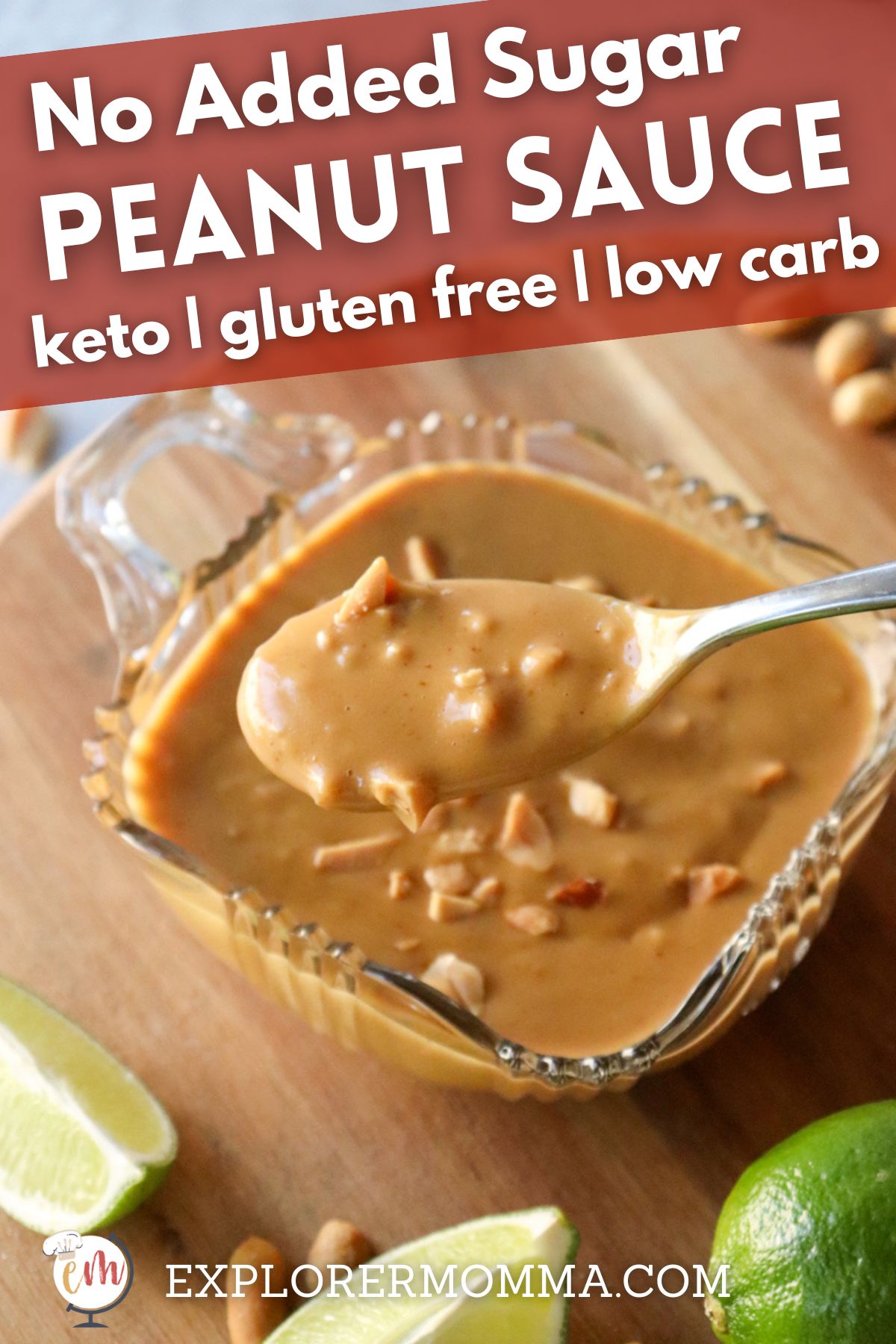 A close up of a glass bowl of low carb Thai peanut sauce sprinkled with extra peanuts, and a spoon lifting some out