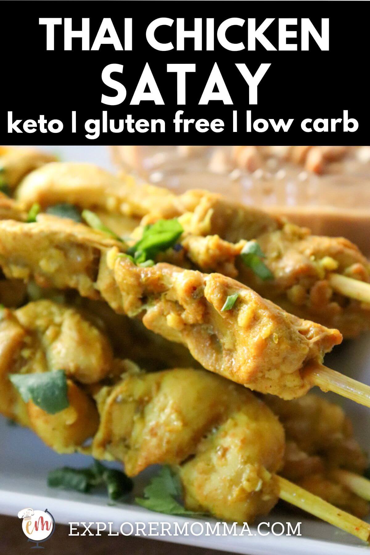 Keto chicken satay on skewers on a white serving dish with peanut sauce