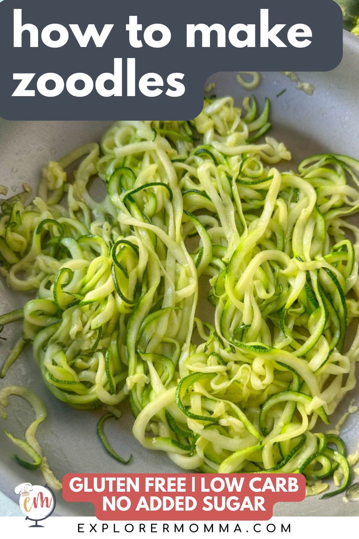 An overhead view of a metal skillet with cooked zucchini noodles (zoodles)