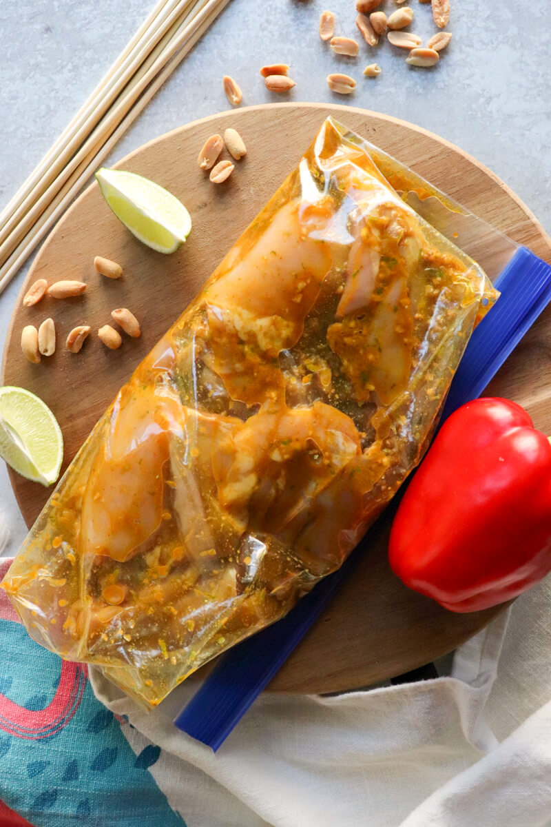 Overhead view of chicken thighs in a zipper bag with Thai marinade