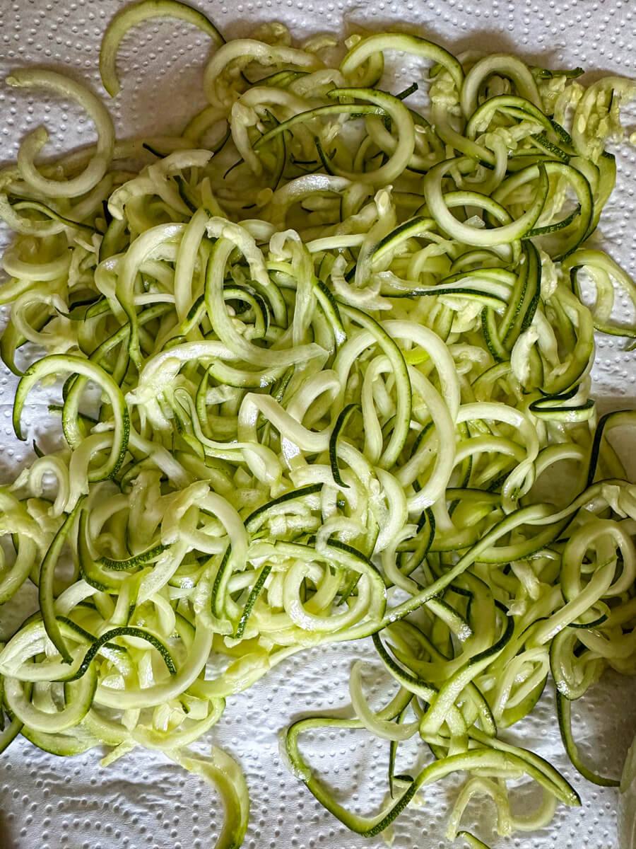 Overhead view of zoodles after salt and draining on paper towels