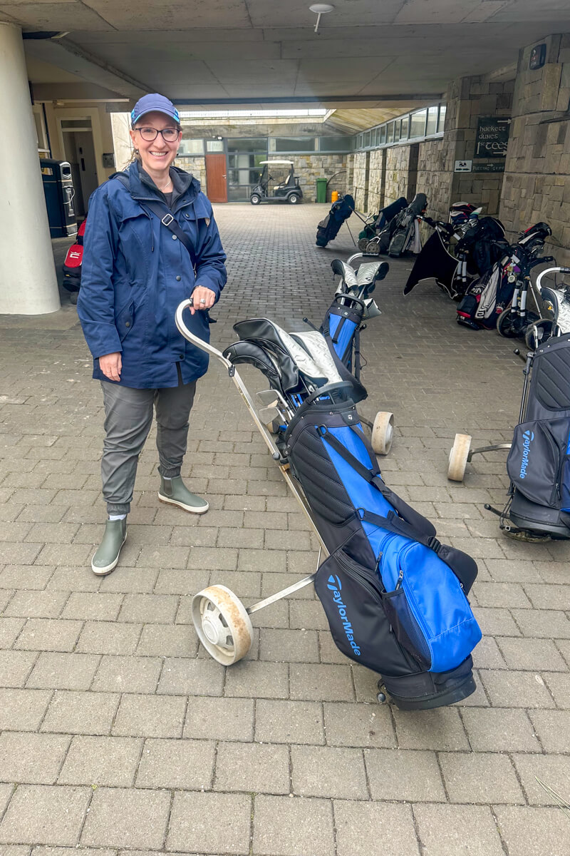 Lauren in a navy baseball hat leaving the clubhouse to golf at Carne Golf Links