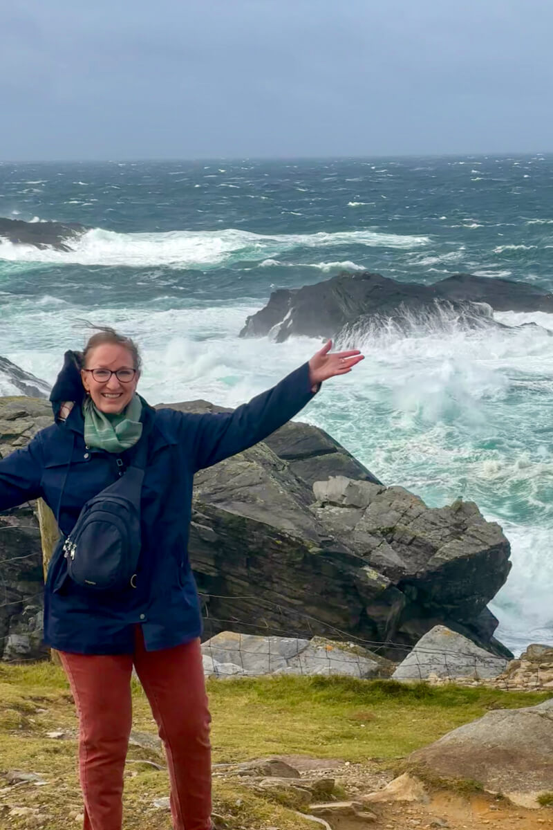 Lauren in front of some wild water and rocks of the Atlantic.