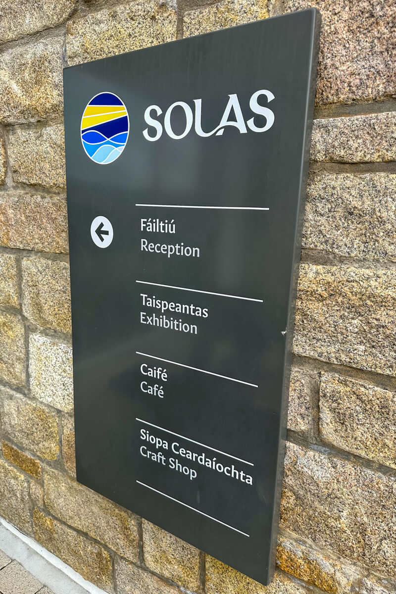 The Solas Visitor Center sign on the brick wall.