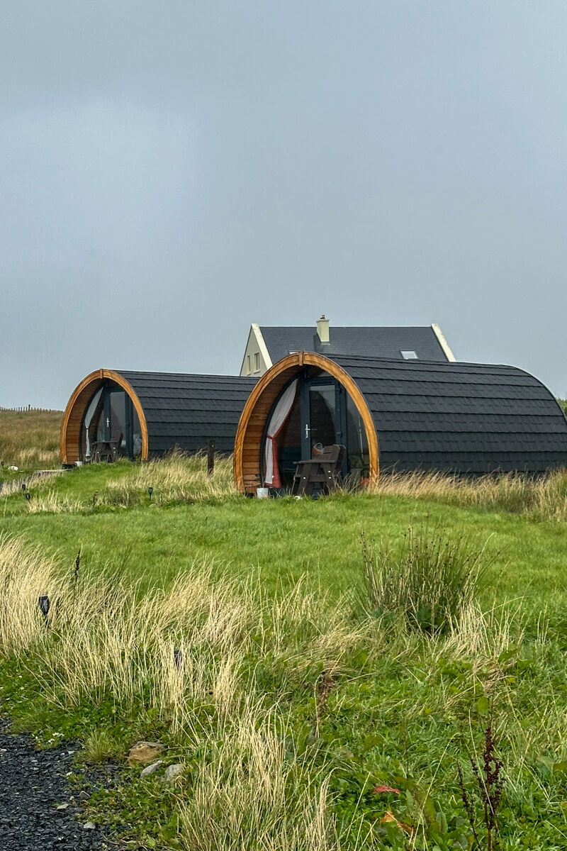 A front view of grass with two of Nanny Goose's circular glamping pods