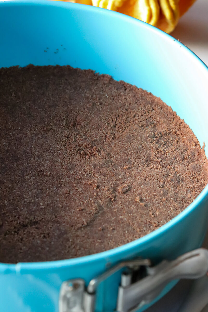Gluten free chocolate crust pressed into the light blue springform pan.