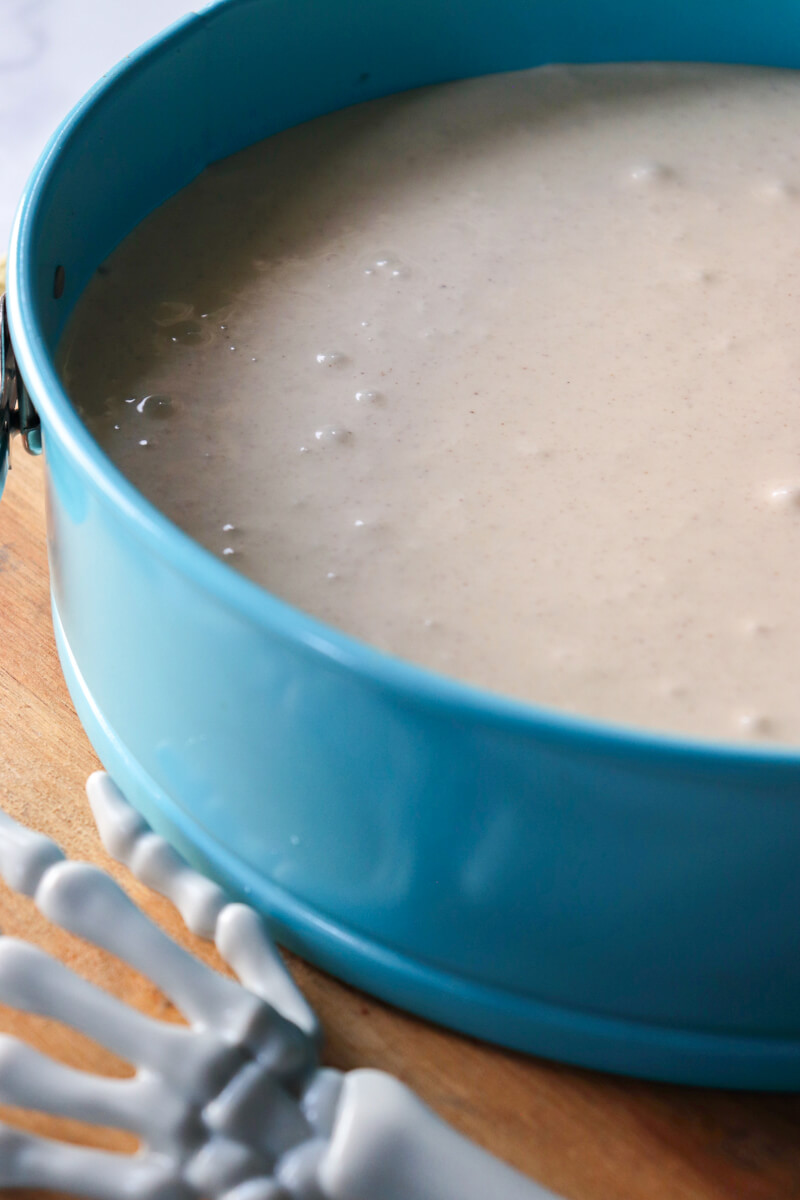 Light blue springform pan with white cheesecake filling.