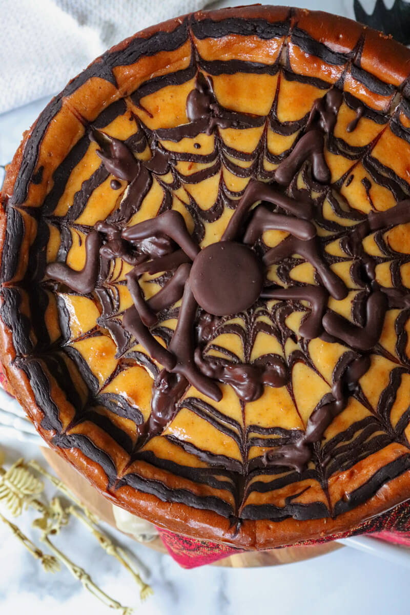 Overhead view of a Keto eggnog cheesecake with a chocolate spider.
