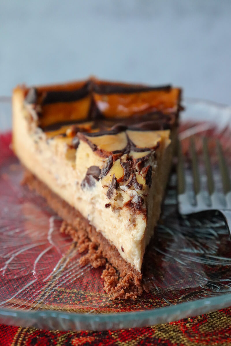 A piece of keto eggnog cheesecake on a glass plate front view.