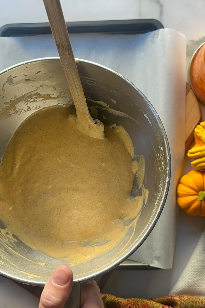 A metal bowl of keto pumpkin roll batter and a spatula
