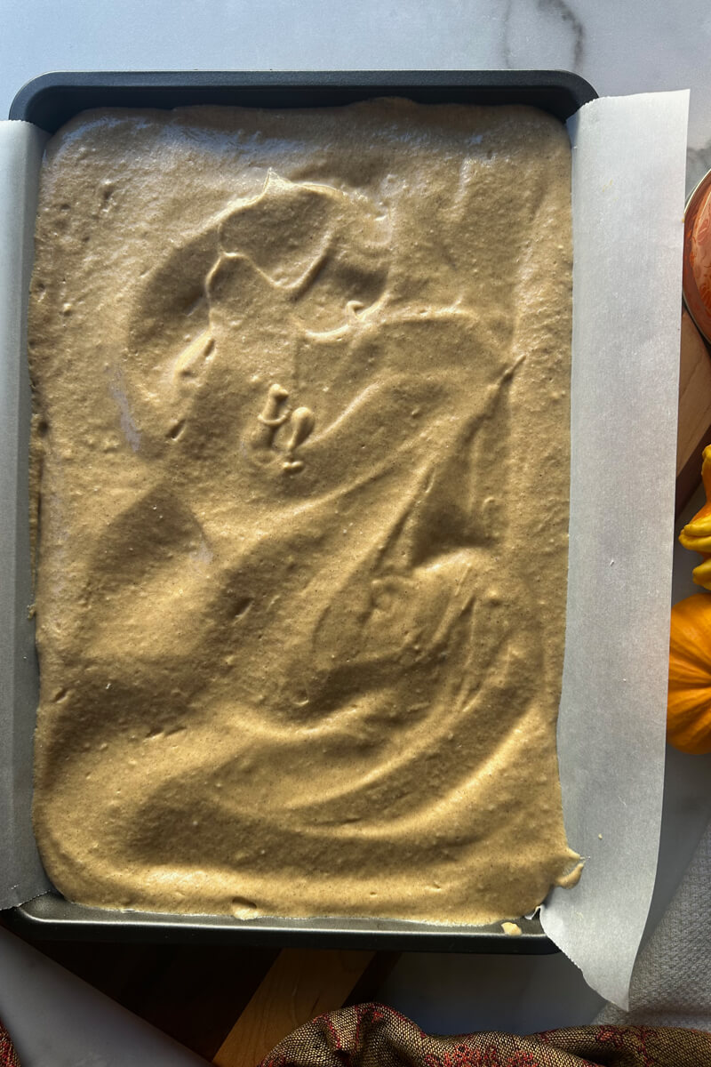 Overhead view of the jelly roll pan with parchment paper and full of batter to bake