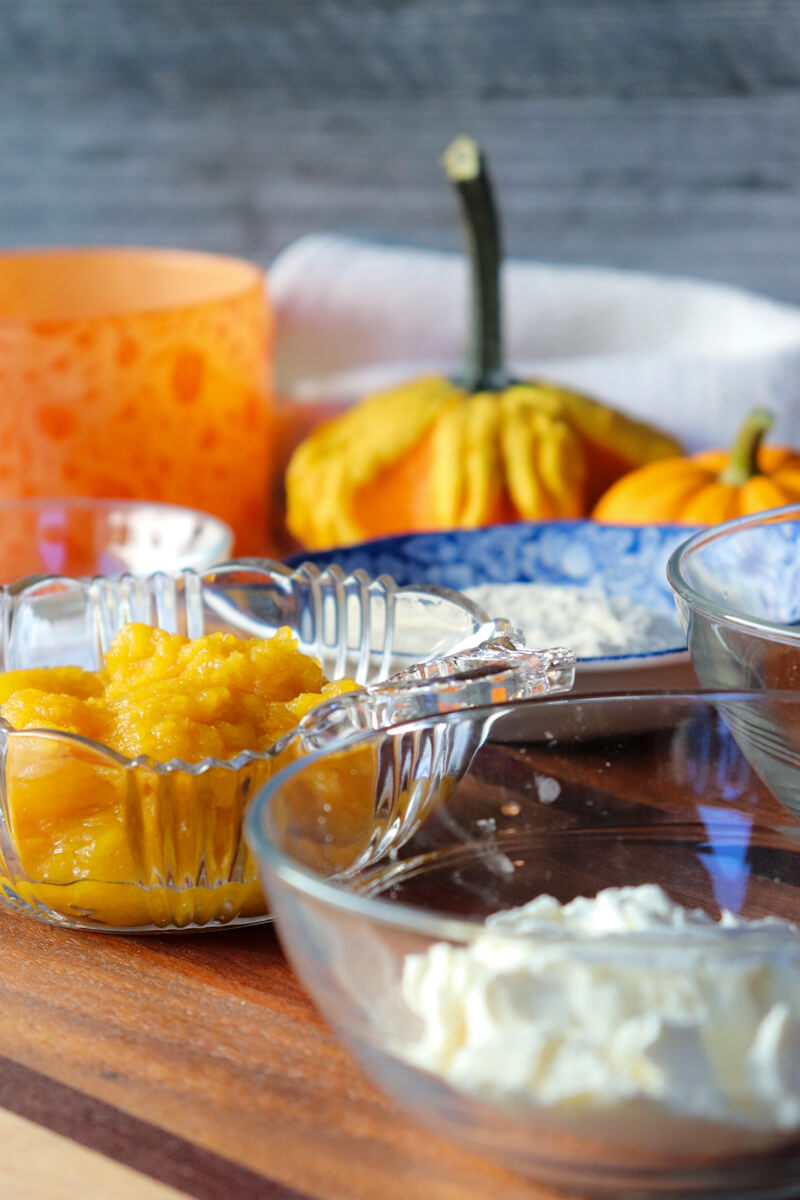 Glass bowls of ingredients: spices, pumpkin, baking powder, salt, etc.