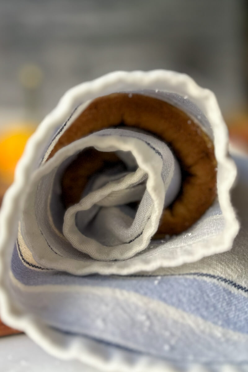 Side view of the keto pumpkin sponge cake rolled in a towel and cooled