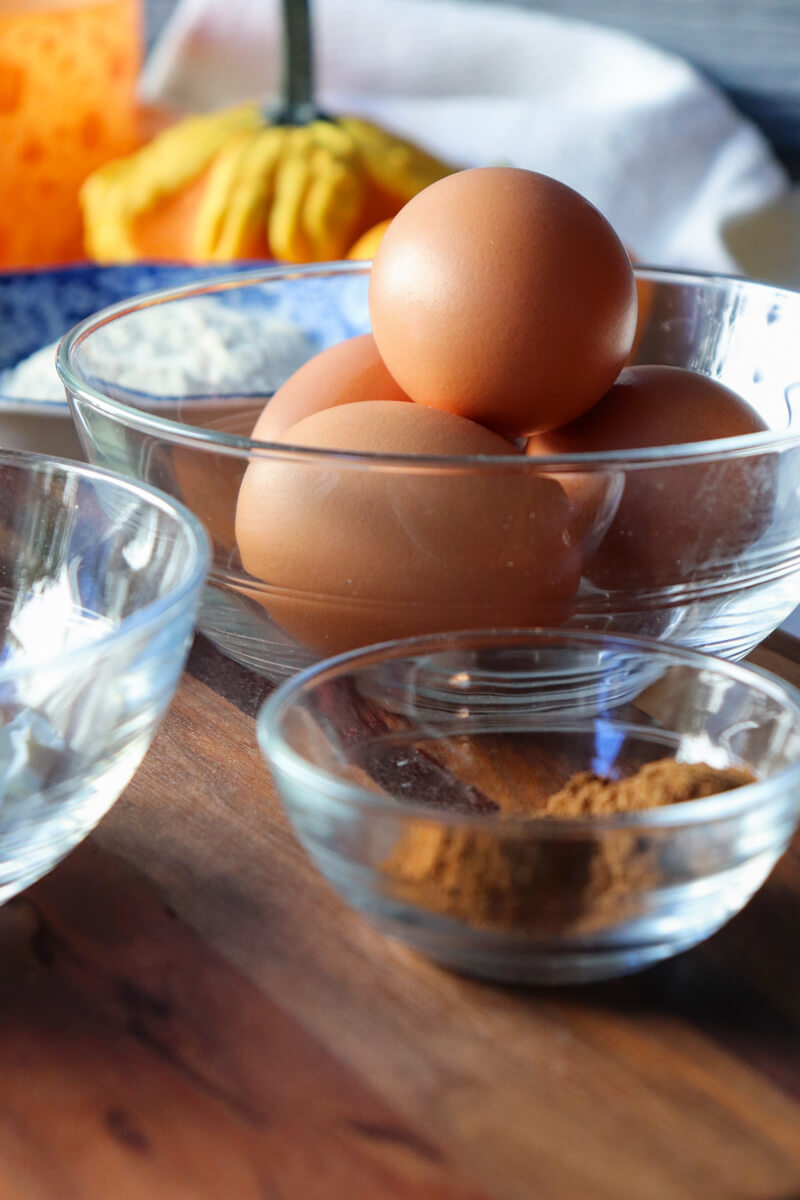 Glass bowls of ingredients, eggs spices, baking powder, salt, etc.