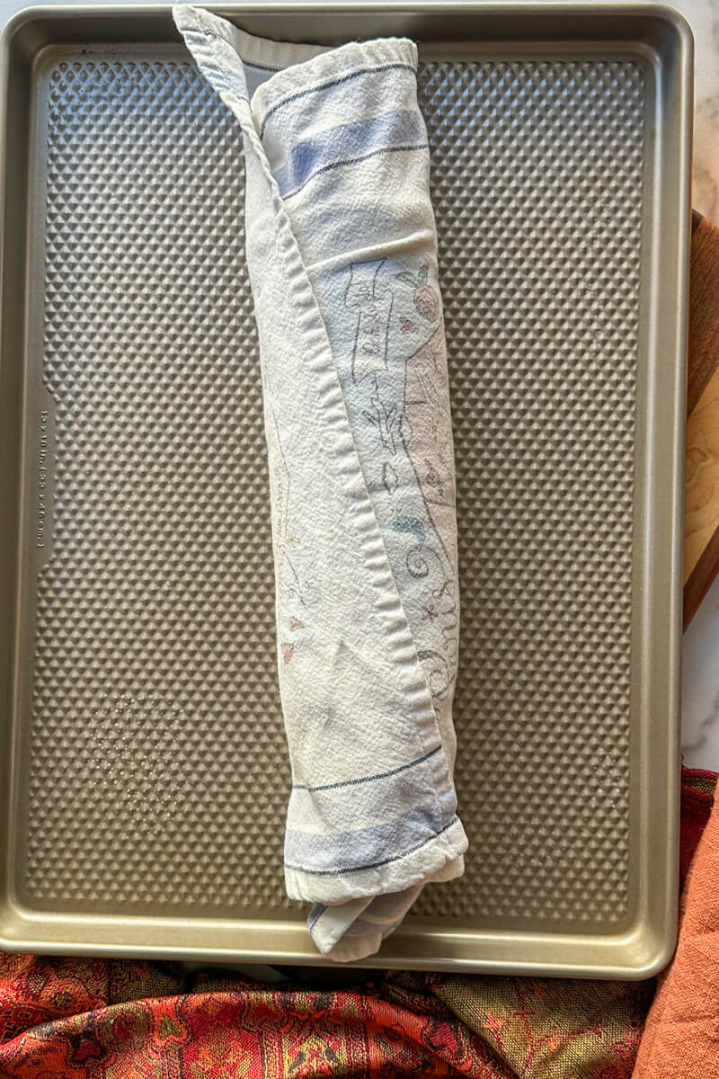 Overhead view of the keto pumpkin sponge cake rolled in a towel and cooled