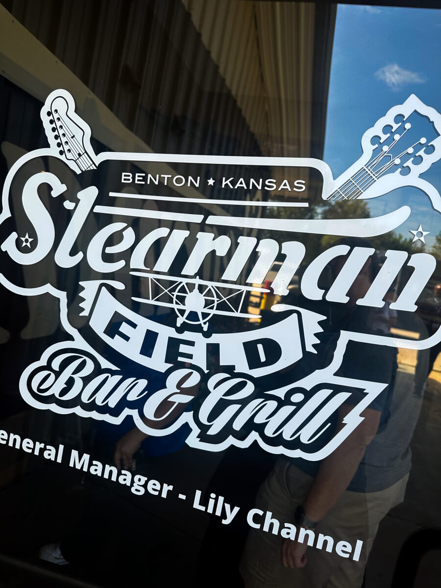 White print on the door of the restaurant: Stearman Field Bar & Grill