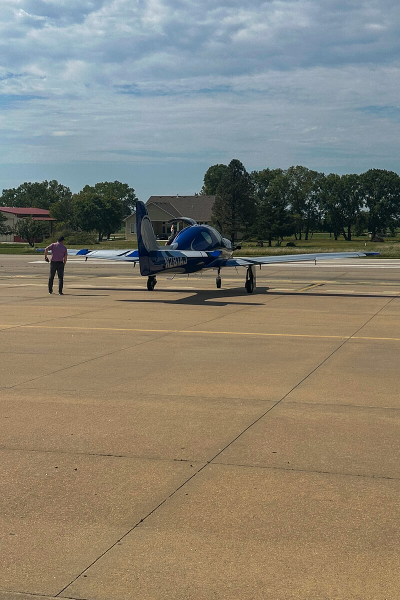 A small airplane on the concrete air field runway area