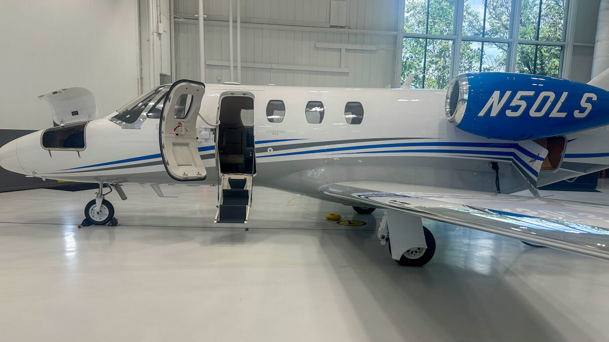 The door with metal stairs leading up to the white airplane