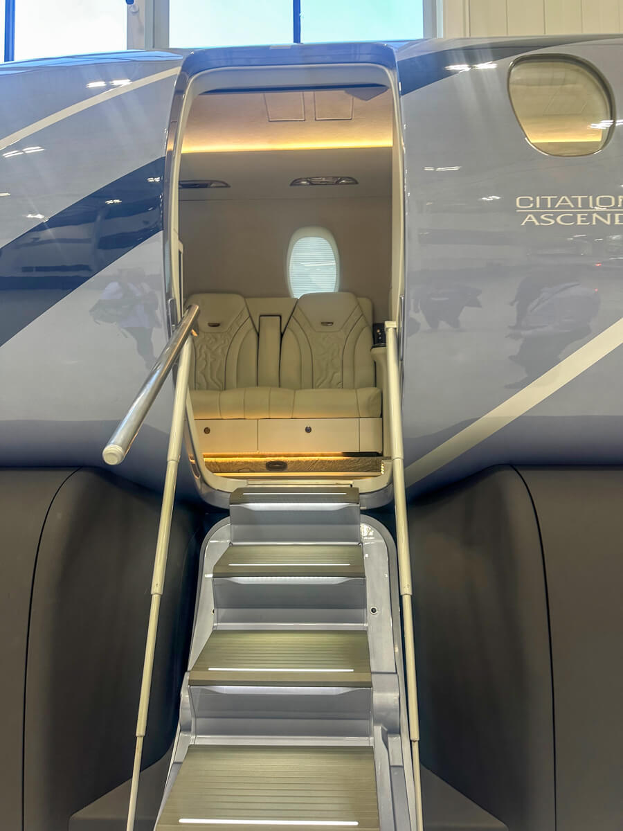 The door with metal stairs leading up to the white airplane