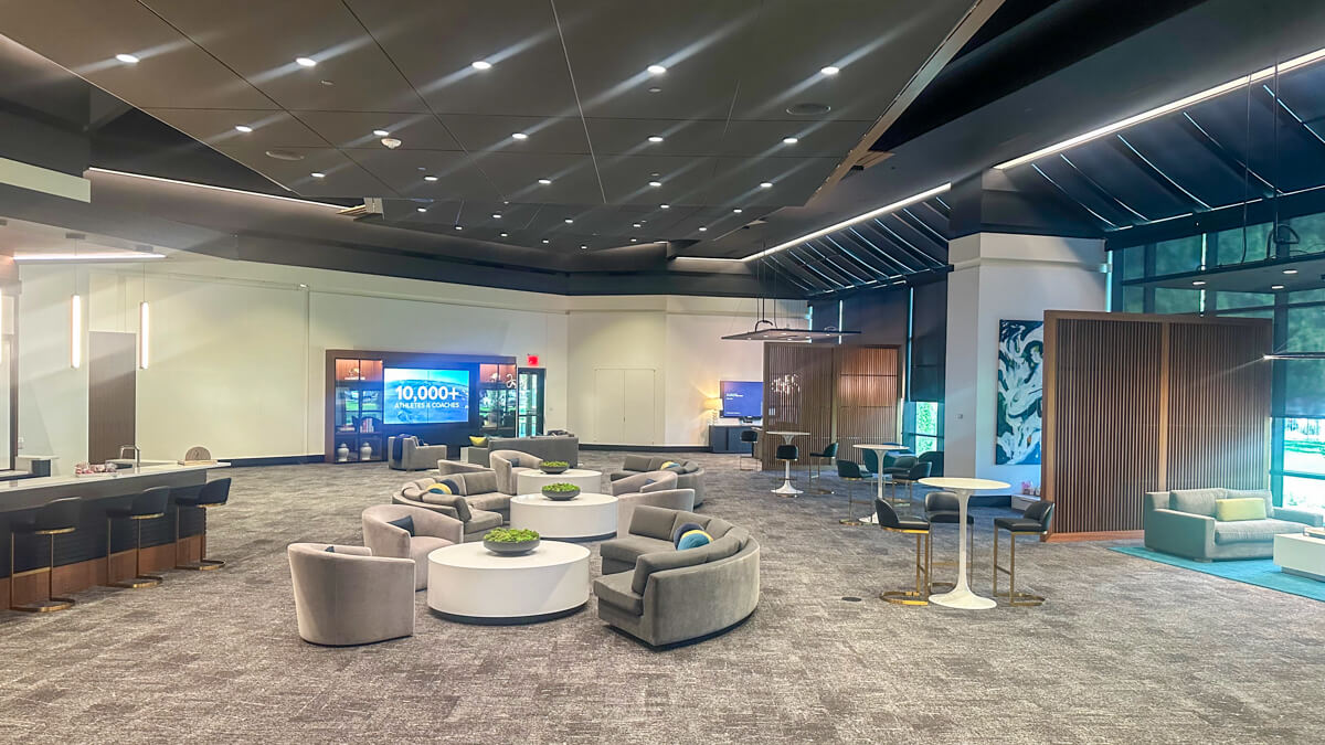 Inside the waiting area at Textron. Gray floor, and puffy gray circular seating areas. White circular tables, etc.