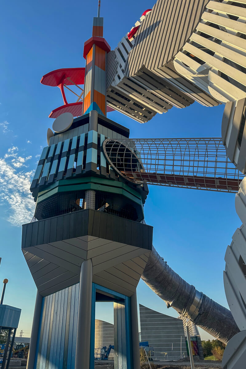 Play area tower with a red airplane at the top, a walkway, slide, etc.