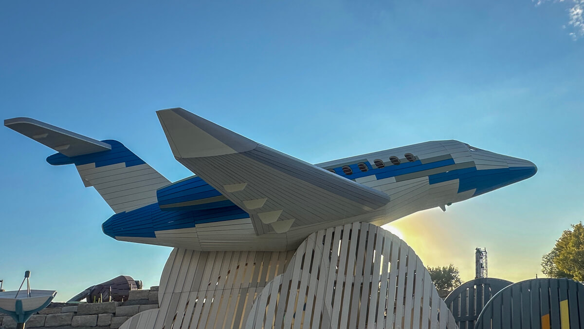 A white and blue airplane with blue sky in the background
