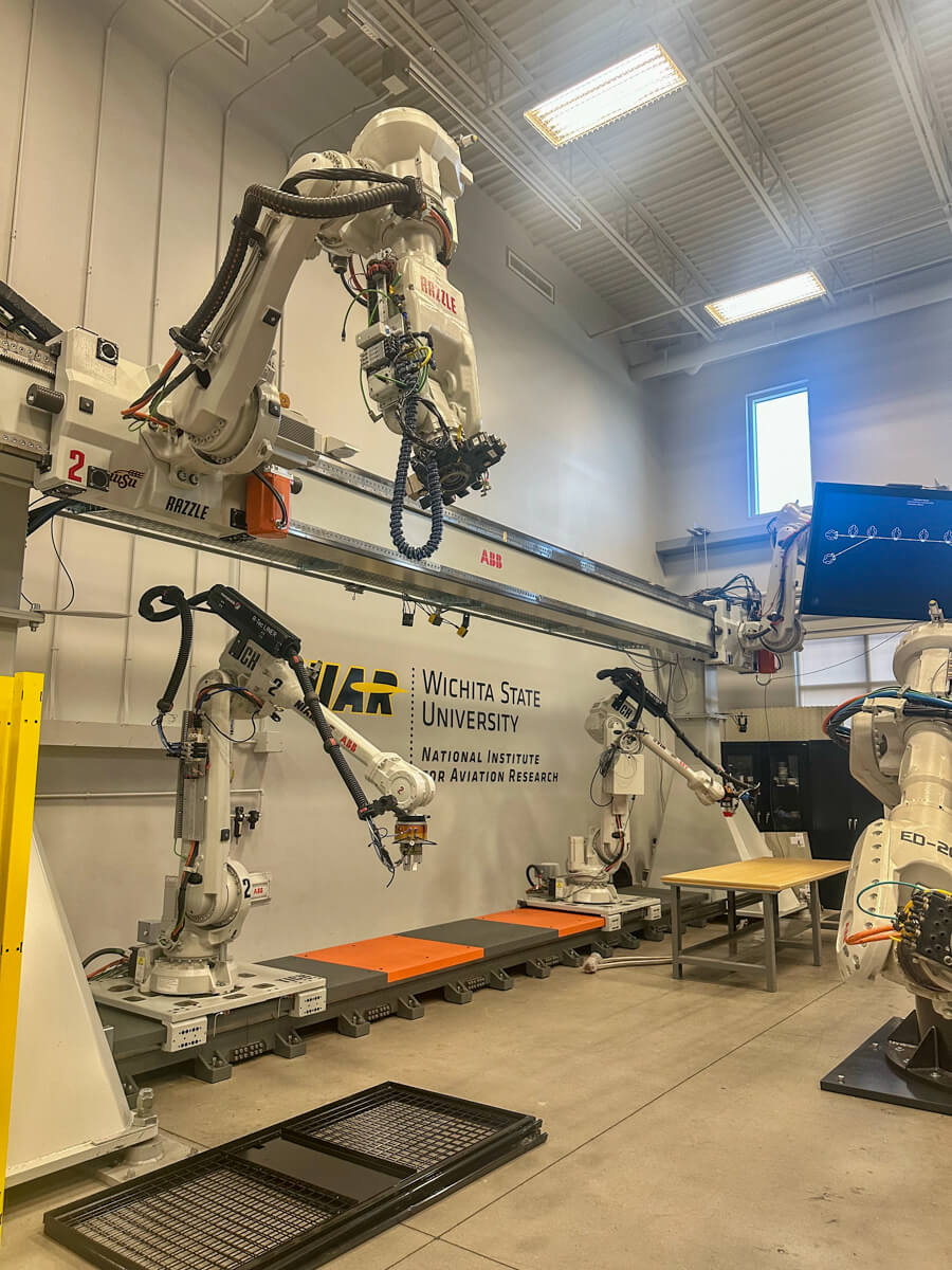 Large open room with large robotic arms and equipment with a small window in the upper corner