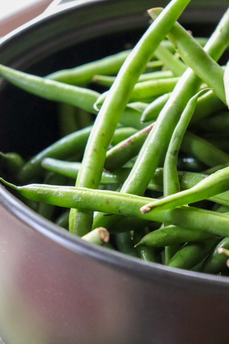 Black pan of raw green beans