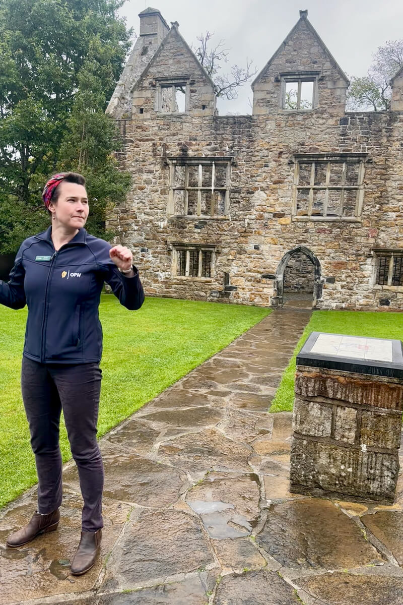 Emma in jeans and a navy jacket speaks just outside of Donegal Castle