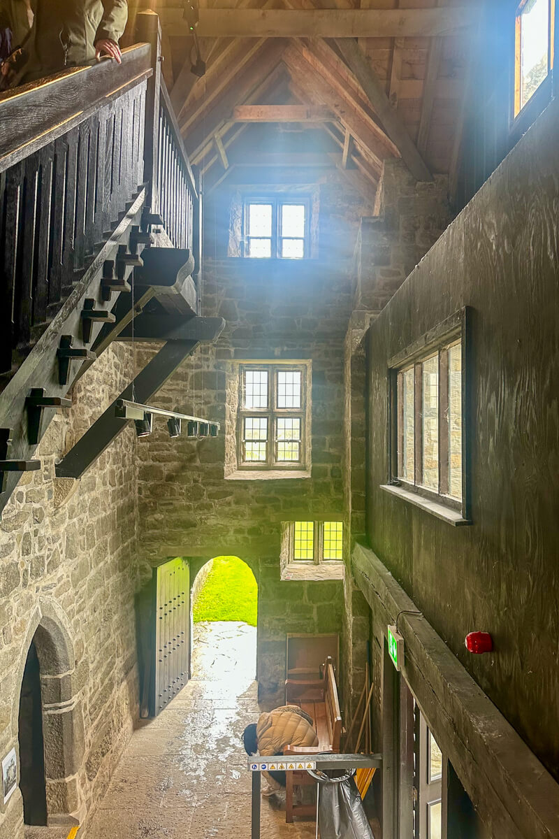Inside view of the castle staircase with sunshine streaming in the windows in the stone walls