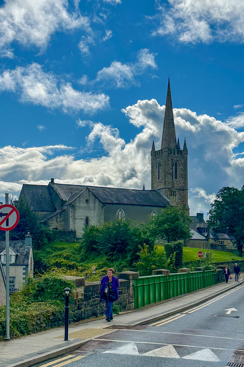 Beautiful side view of the Donegal Town Church of Ireland with puffy white clouds and a bright blue sky