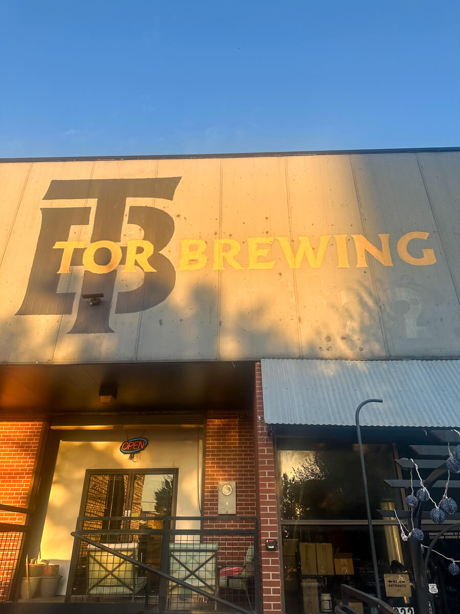 The front of Tor Brewing in Wichita, a sign with the restaurant name over the glass doors and entrance