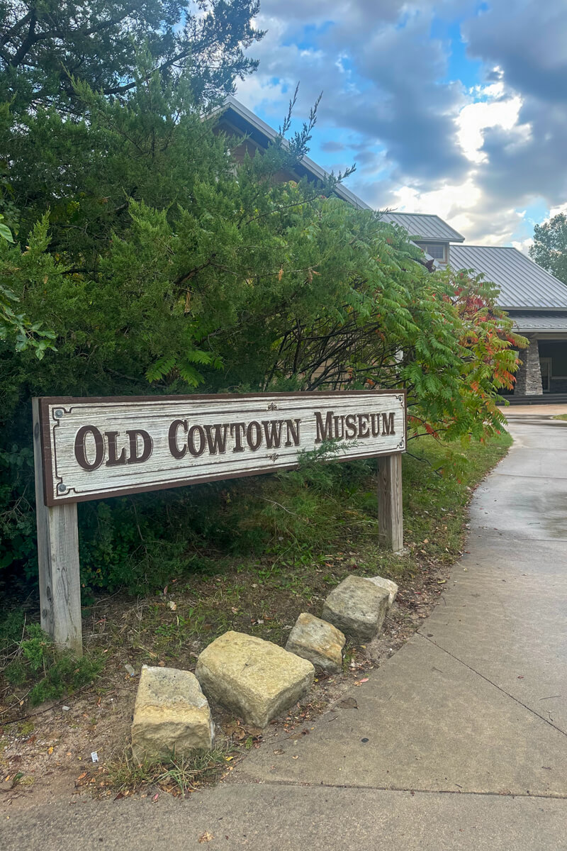 The Old Cowtown Museum wooden sign next to a path