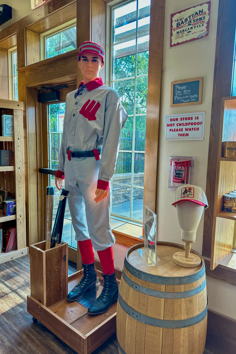 A mannequin wearing a vintage baseball uniform in front of some windows