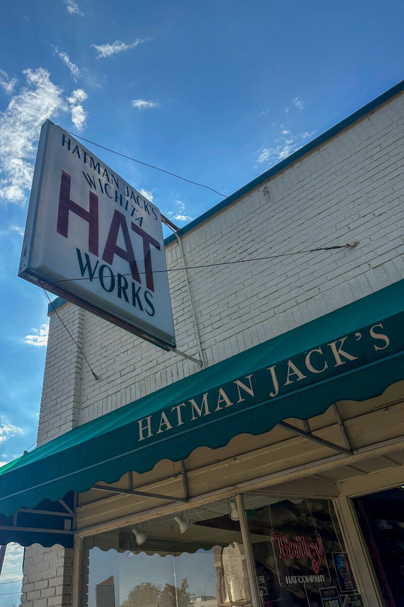 The front entrance to Hatman Jacks with a white sign and green awning