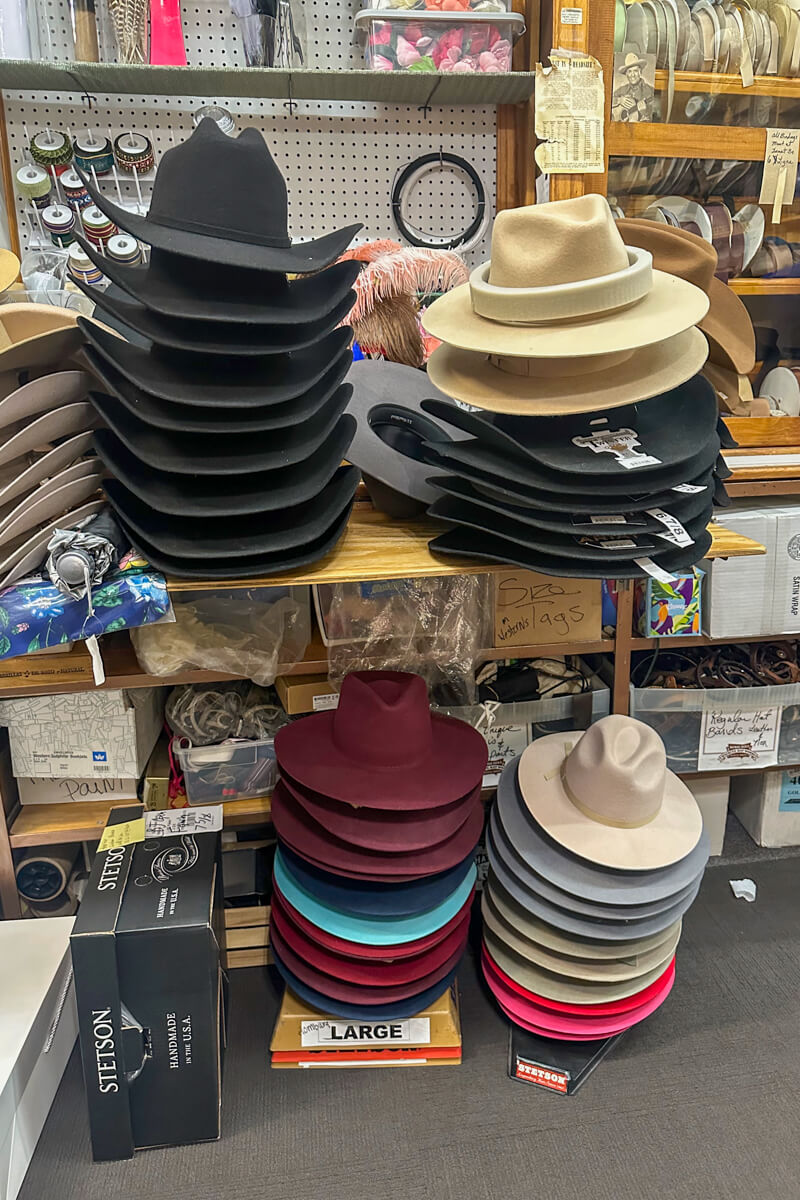 Stacks of multi-colored hats on a table and under