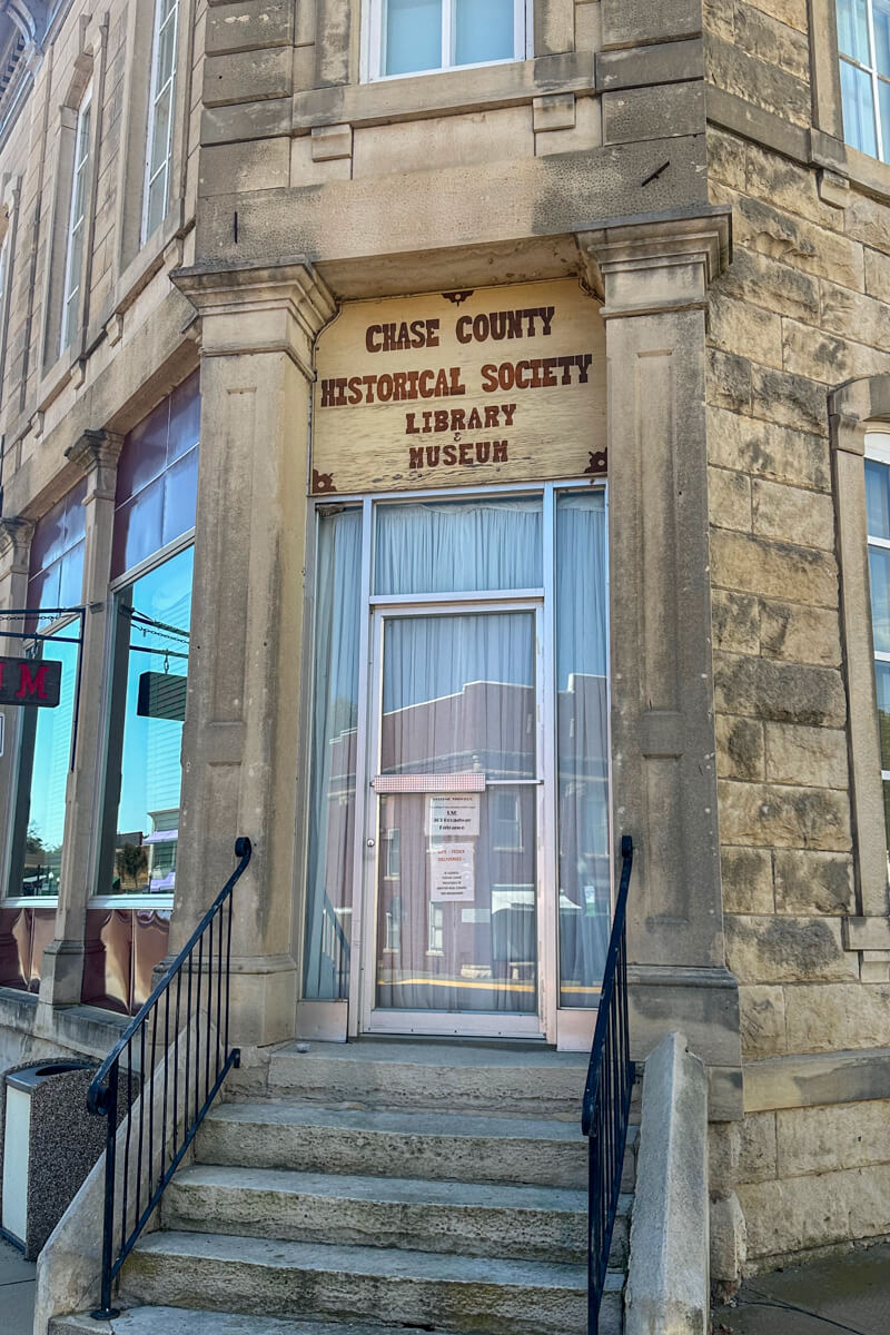 Concrete stairs leading up to he Chase County Historical Society building in light tan stone