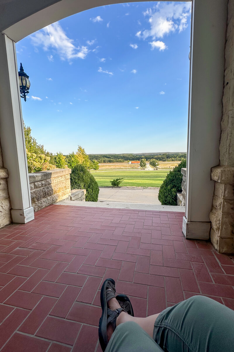 Legs with sandaled feet looking out the front porch and view of the Clover Cliff Ranch