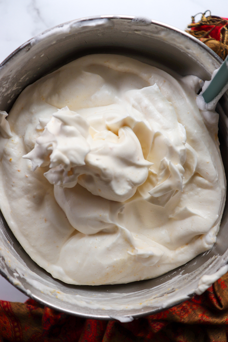 Overhead a metal bowl of whipped egg white batter