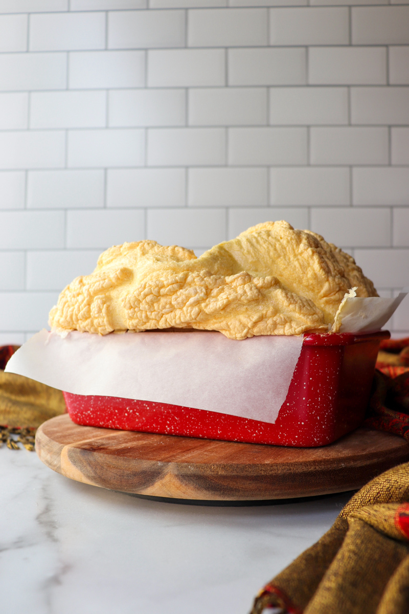 Side view of a loaf of egg white protein bread cooling in the pan