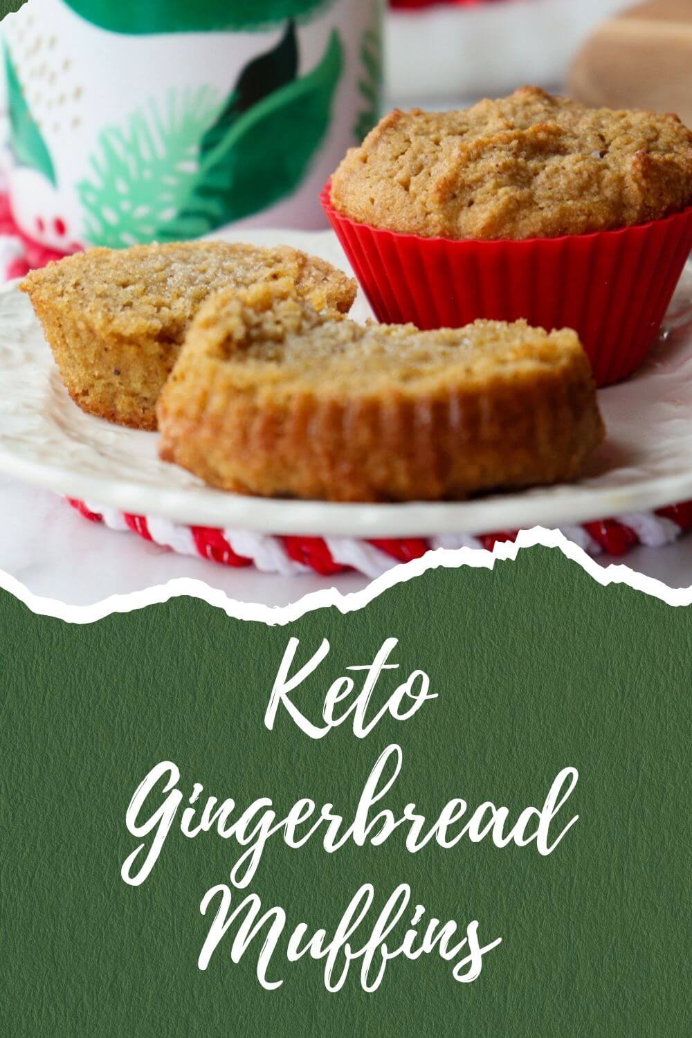 A white plate with two muffins, one still in a red silicone cup and the other cut in two halves with melted butter. A white mug with green leaves is in the background. Text overlay, Keto Gingerbread Muffins".