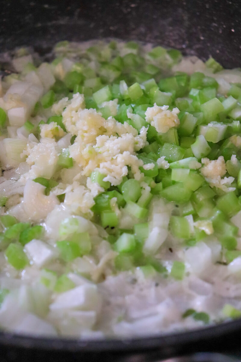 A sauté pan with onion, celery, garlic, butter, etc.