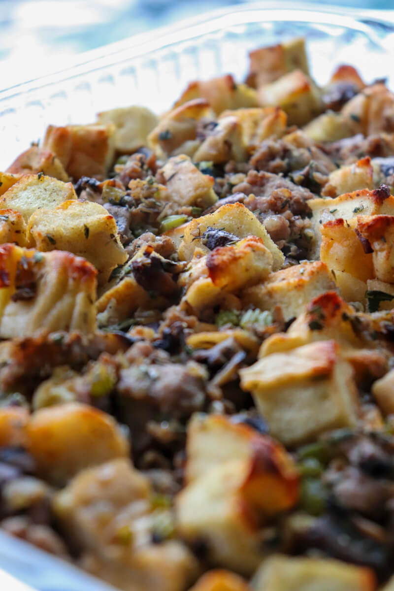 Close up front view of A glass dish of cooked keto stuffing with toasted protein bread and sausage