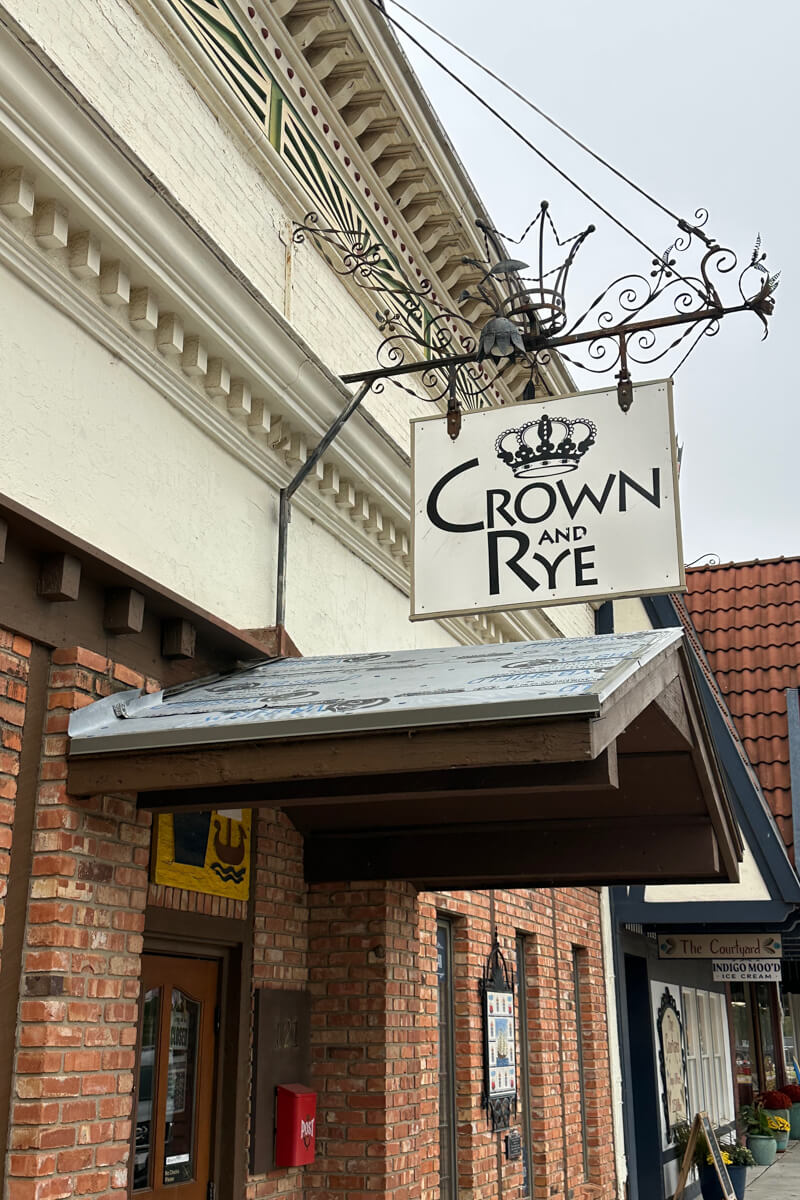 A store front with a cast iron sign with a crown picture and "Crown and Rye"