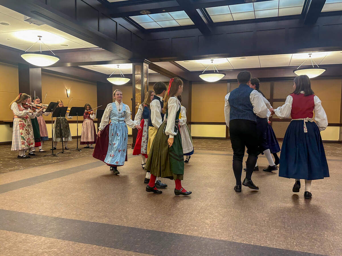 Swedish traditional dancers in costume and musicians in the corner