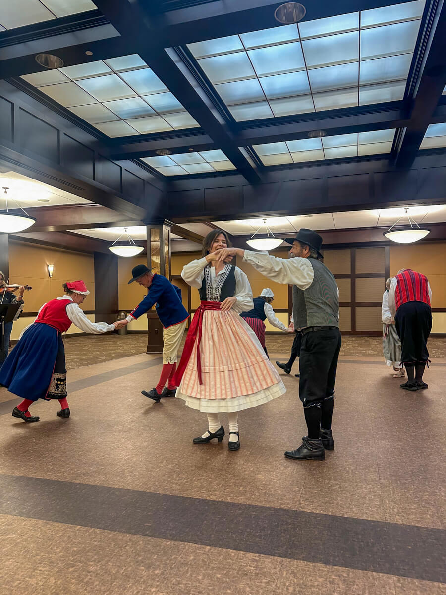 Swedish traditional dancers in costume and musicians in the corner