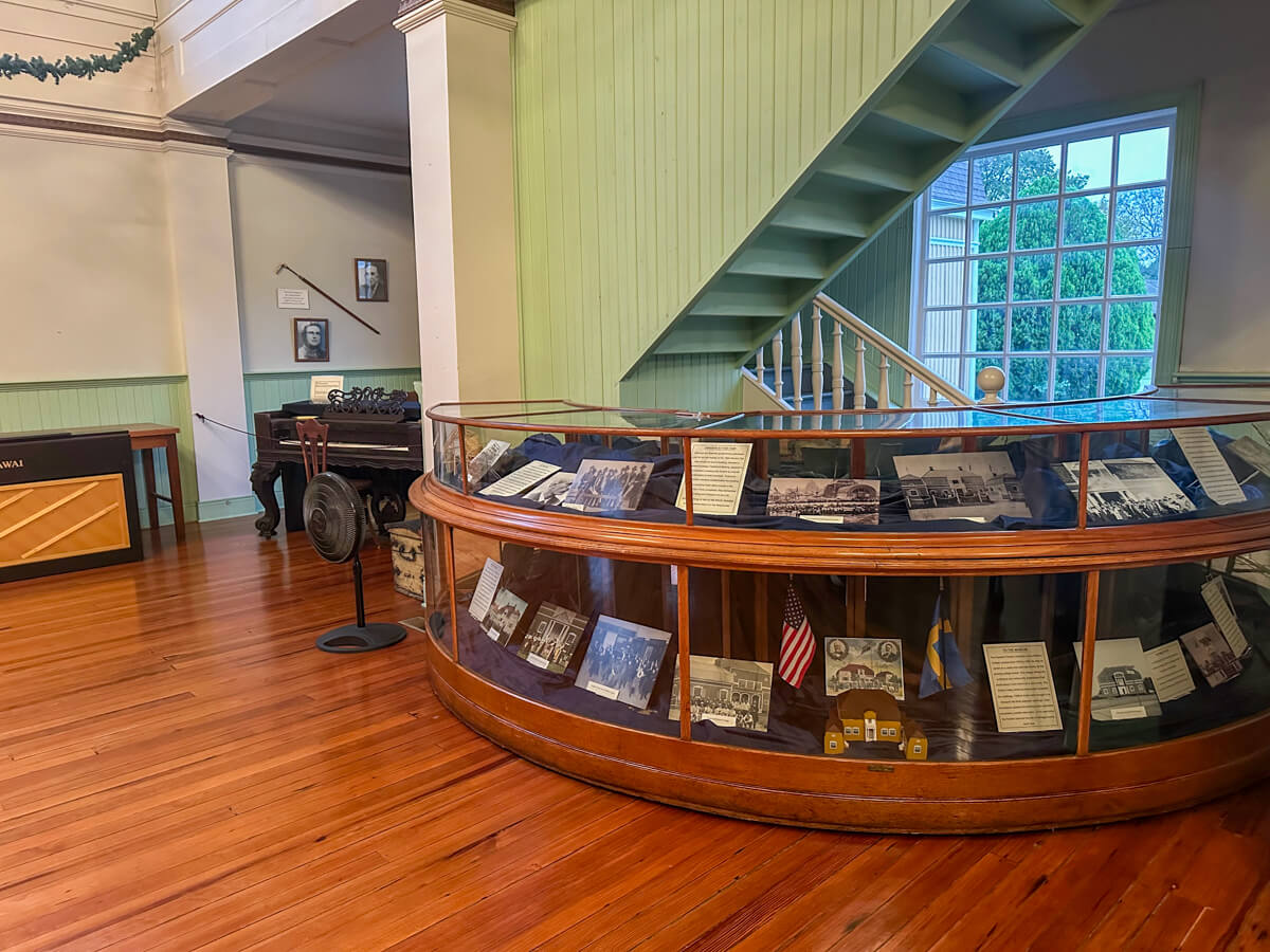 Inside the hall at the Old Mill museum with a wooden floor and display.
