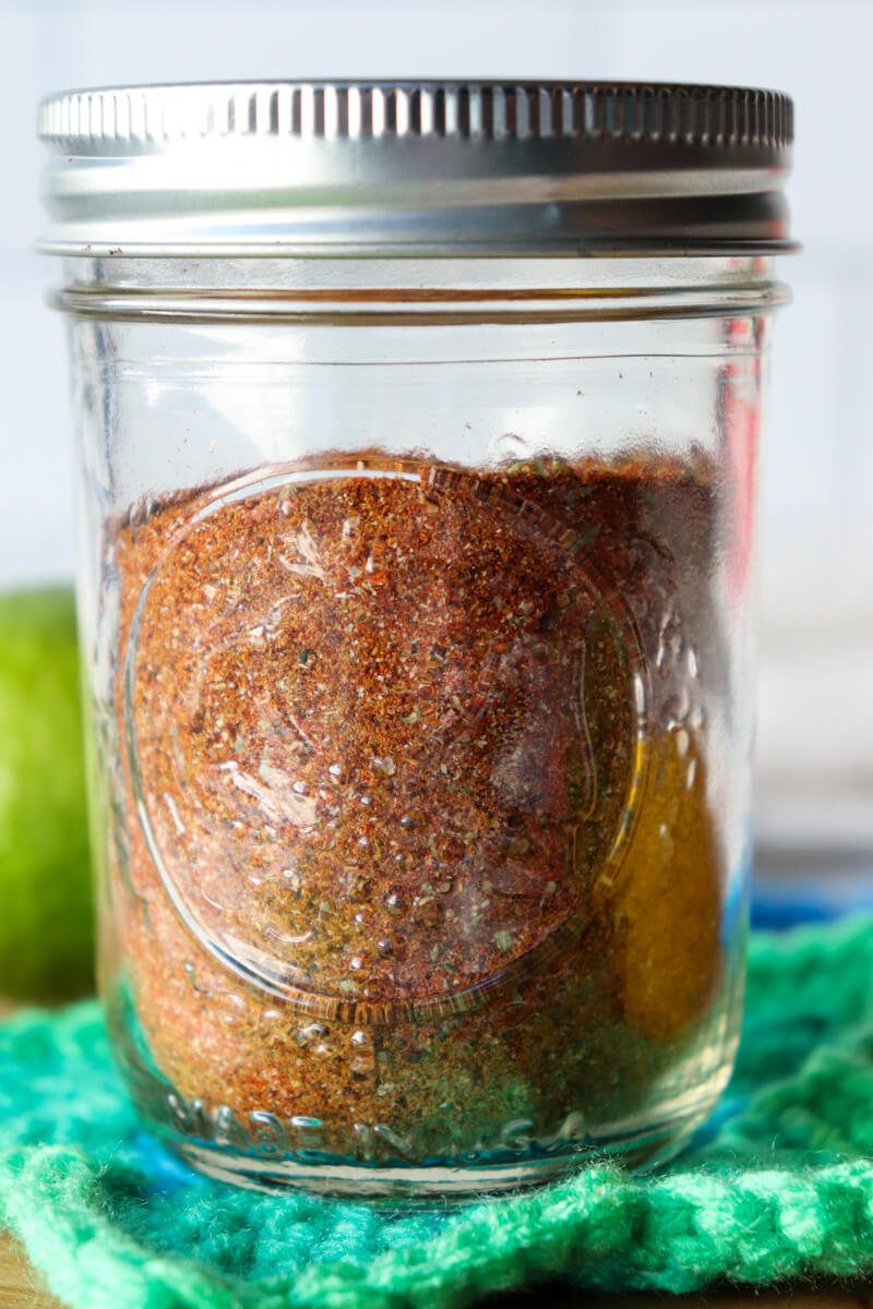 A glass Ball jar filled with keto chicken taco seasoning on a crocheted green star coaster